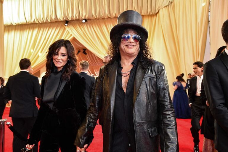 Meegan Hodges y Slash, de la manito a su ingreso a la gala de los Premios Óscar 2024. (Valerie Macon / AFP)