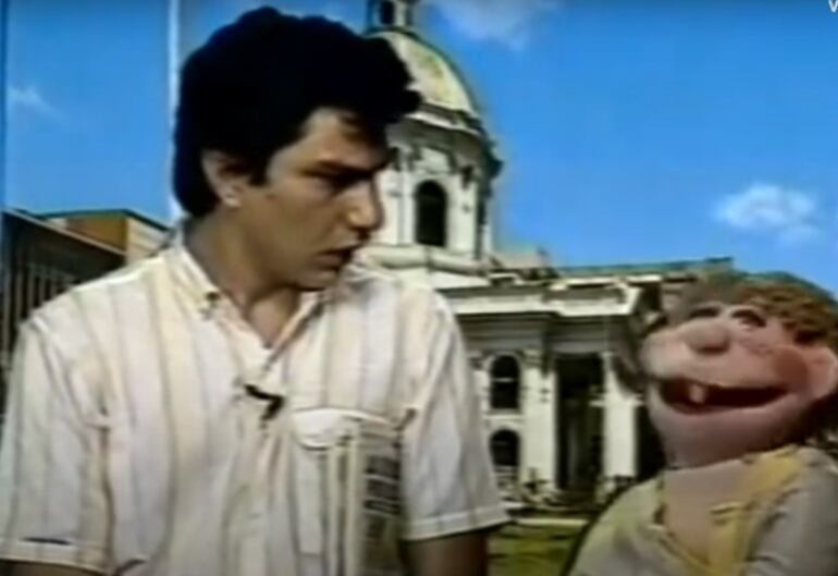 El actor Miguel Ángel Pereira Acosta y el personaje de "Kube", con el Panteón de los Héroes detrás, en una captura de un spot televisivo de los años '80.