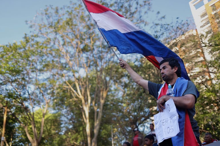 Un hombre sostiene una bandera durante una manifestación en el Día Internacional de los Derechos Humanos, en Asunción (Paraguay).