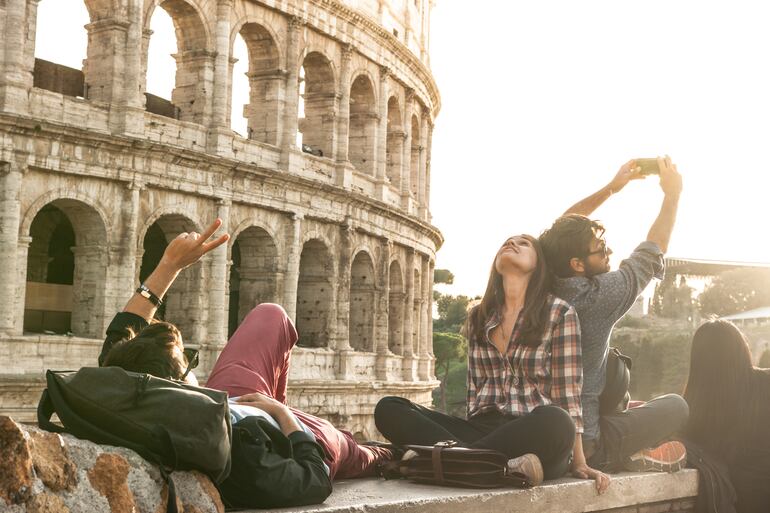 Turistas posan frente al Coliseo, Roma, Italia.