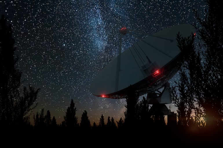 Radiotelescopio, una gran antena satelital contra el cielo nocturno, rastrea a las estrellas. Imagen ilustrativa de la búsqueda de vida extraterrestre, o interceptación del espacio.