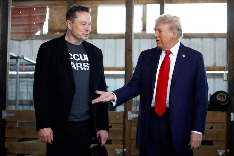 Donald Trump, ofrece su mano al director ejecutivo de Tesla y SpaceX, Elon Musk, detrás del escenario durante un mitin de campaña.