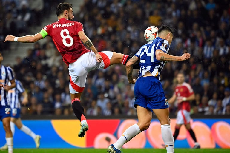 Manchester United's Portuguese midfielder #08 Bruno Fernandes fouls FC Porto's Argentine defender #24 Nehuen Perez during the UEFA Europa League 1st round day 2 between FC Porto and Manchester United at the Dragao stadium in Porto on October 3, 2024. (Photo by MIGUEL RIOPA / AFP)