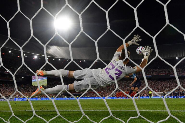 Spain's goalkeeper Unai Simon jumps to stop one of the penalty shootouts during the UEFA Nations League final football match between Croatia and Spain at the De Kuip Stadium in Rotterdam on June 18, 2023. (Photo by JOHN THYS / AFP)