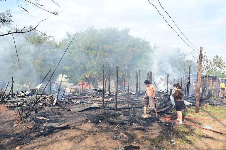 Las familias intentan rescatar algunas de sus pertenencias, tras el incendio que afectó a aproximadamente 10 casas esta mañana en zona de la Chacarita.