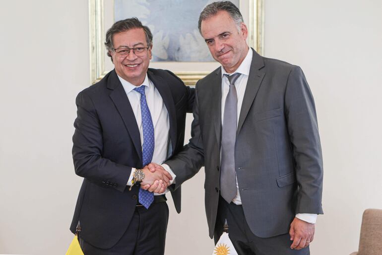 El presidente electo de Uruguay, Yamandú Orsi (d), saluda al presidente de Colombia, Gustavo Petro.