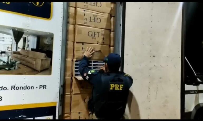 Un camión repleto de cigarrillo es verificado por un agente de la Policía Rodoviaria Federal de Brasil.