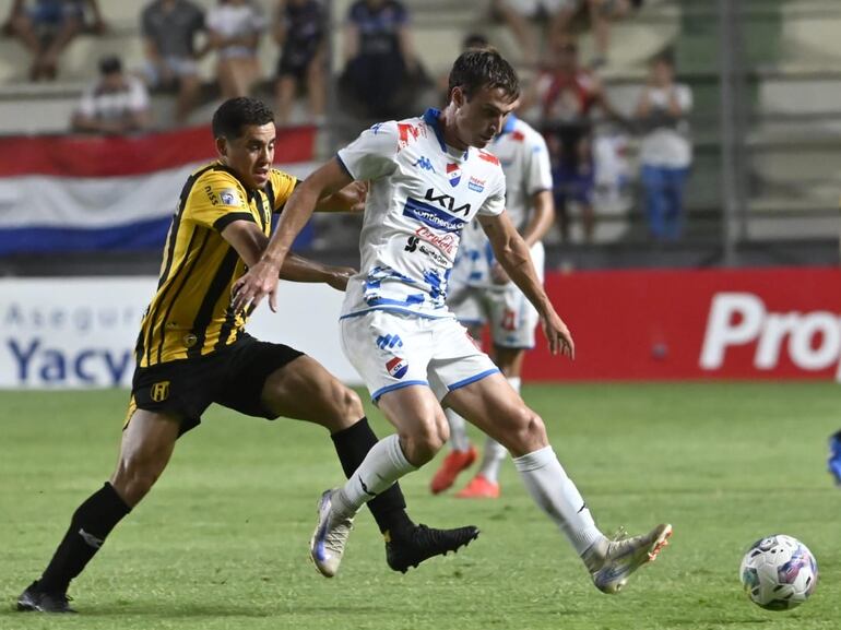 El argentino Nicolás Barrientos (i), jugador de Guaraní, pelea por el balón en un partido frente a Nacional por el fútbol paraguayo en le estadio Arsenio Erico, en Asunción.