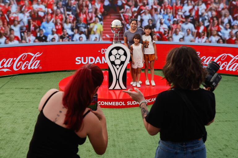 Personas posan junto al trofeo de la Copa Sudamericana en la Fiesta Sudamericana en la ciudad de Asunción, Paraguay. 