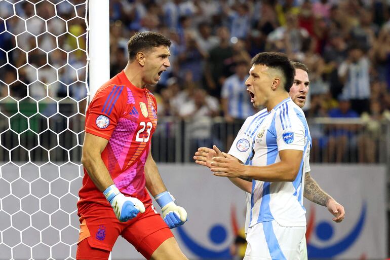 Argentina's goalkeeper #23 Emiliano Martinez (L) celebrates with Argentina's defender #25 Lisandro Martinez after Ecuador's forward #13 Enner Valencia (out of frame) missed a goal from the penalty spot during the Conmebol 2024 Copa America tournament quarter-final football match between Argentina and Ecuador at NRG Stadium in Houston, Texas, on July 4, 2024. (Photo by CHARLY TRIBALLEAU / AFP)