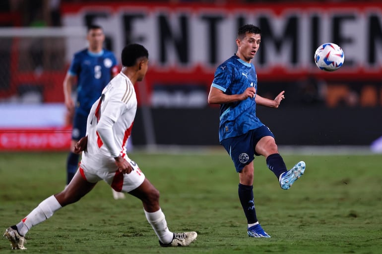 Andrés Cubas (d), jugador de la selección paraguaya, lanza el balón en un partido amistoso frente Perú en el estadio Monumental, en Lima, Perú.