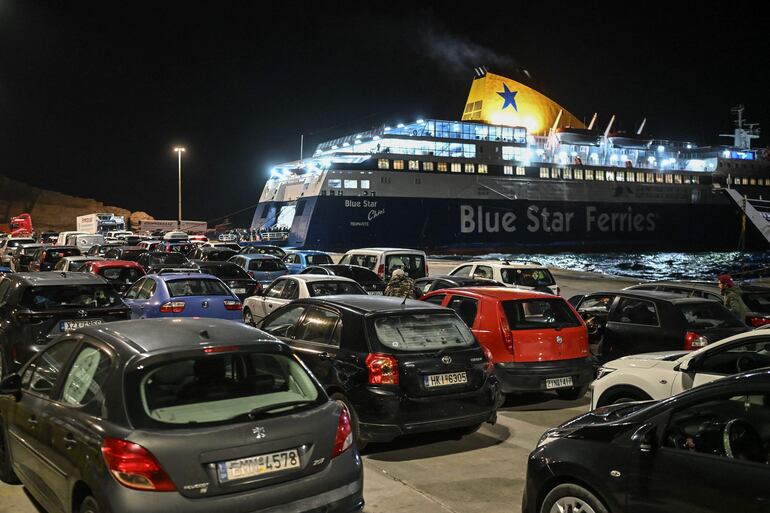 Los automóviles hacen cola para embarcar en un ferry mientras la gente sale a raíz de los recurrentes terremotos, en la isla griega de Santorini.