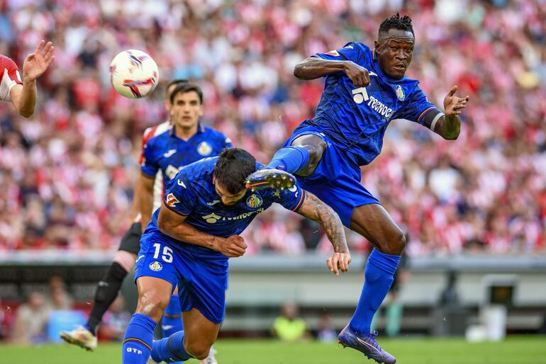 BILBAO, 15/08/2024.- El defensa paraguayo del Getafe CF Omar Alderete (i) y su compañero Christantus Uche (d) intentan rematar el balón, durante el partido de Liga en Primera División ante el Athletic Club, que disputan este jueves en el estadio de San Mamés, en Bilbao. EFE/Javier Zorrilla
