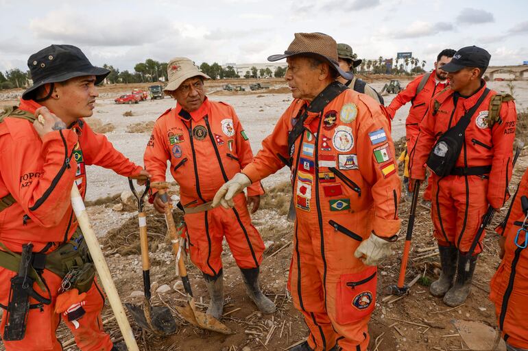 Un grupo de rescatistas mexicanos, de la Brigada Internacional de Rescate Topos Azteca, durante las tareas de búsqueda y rescate en la rambla del Poyo, una de las principales vías que recorrió el agua durante la riada, este jueves en Valencia.