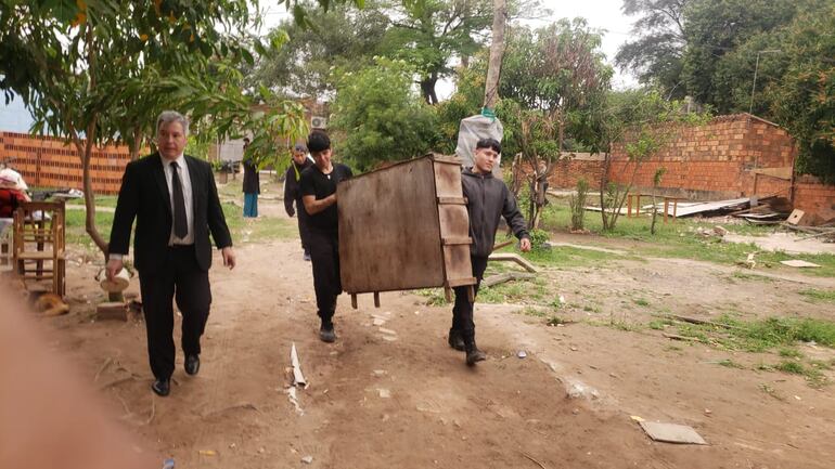 Ocupantes sacando sus pertenencias del terreno en conflicto.