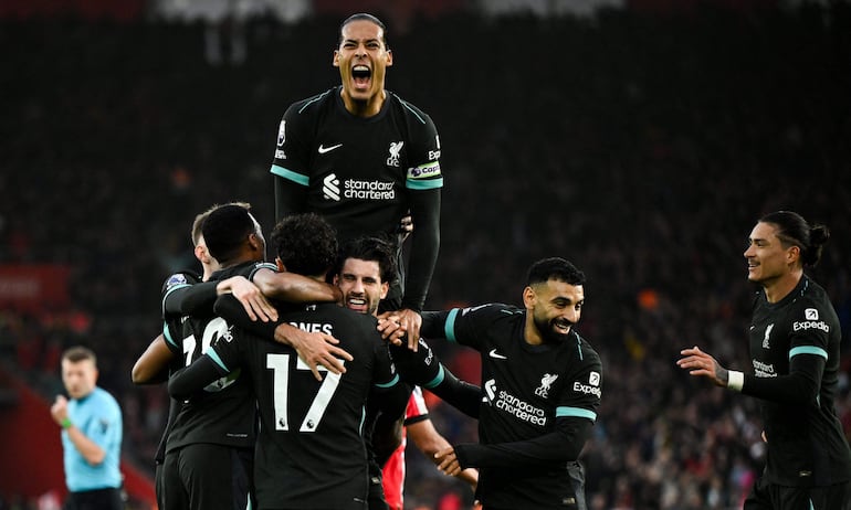 TOPSHOT - Liverpool's Hungarian midfielder #08 Dominik Szoboszlai (C) celebrates with teammates after scoring his team first goal during the English Premier League football match between Southampton and Liverpool at St Mary's Stadium in Southampton, southern England on November 24, 2024. (Photo by JUSTIN TALLIS / AFP) / RESTRICTED TO EDITORIAL USE. No use with unauthorized audio, video, data, fixture lists, club/league logos or 'live' services. Online in-match use limited to 120 images. An additional 40 images may be used in extra time. No video emulation. Social media in-match use limited to 120 images. An additional 40 images may be used in extra time. No use in betting publications, games or single club/league/player publications. / 