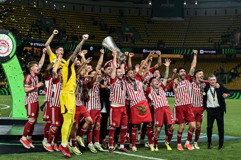 Olympiakos' Greek midfielder #07 Konstantinos Fortounis (C) and Olympiakos' players celebrate with the trophy after winning the UEFA Europa Conference League final football match between Olympiakos and Fiorentina at the AEK Arena in Athens on May 29, 2024. (Photo by Aris MESSINIS / AFP)