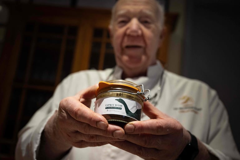 El chef francés Marcel Metzler sostiene un frasco de "Esprit d'oie" en su tienda en Gueberschwihr, en el este de Francia.