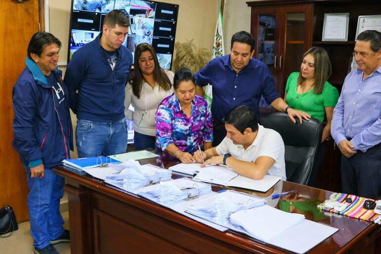 Momento en que el intendente interino de Villa Elisa, Sergio Estigarribia, firma su renuncia al cargo.