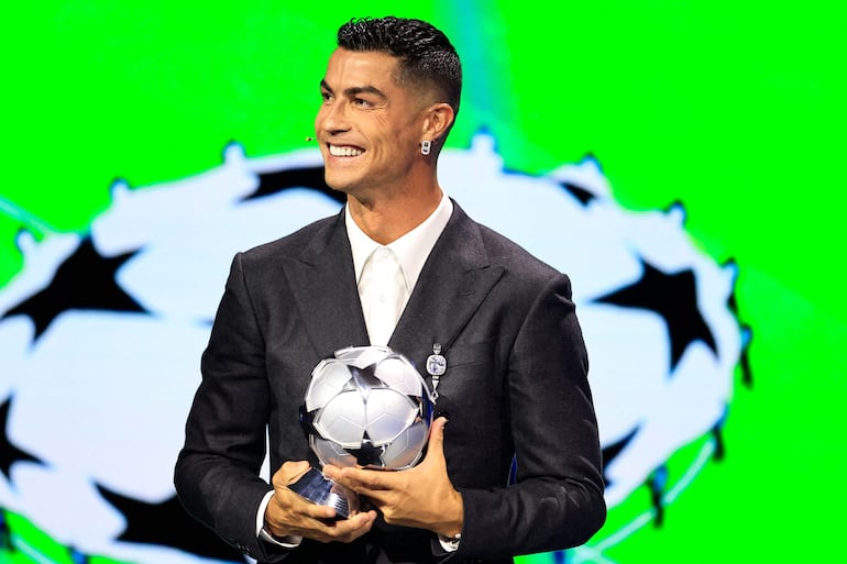 El jugador de la selección portuguesa y delantero del Al-Nassr saudita, Cristiano Ronaldo, sostiene su premio al goleador histórico de la Liga de Campeones de la UEFA, en Mónaco. (Valery HACHE / AFP)