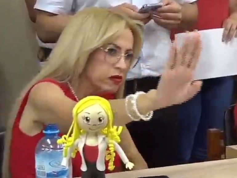 La concejala Carolina González en la Junta Municipal con una muñeca frente suyo.