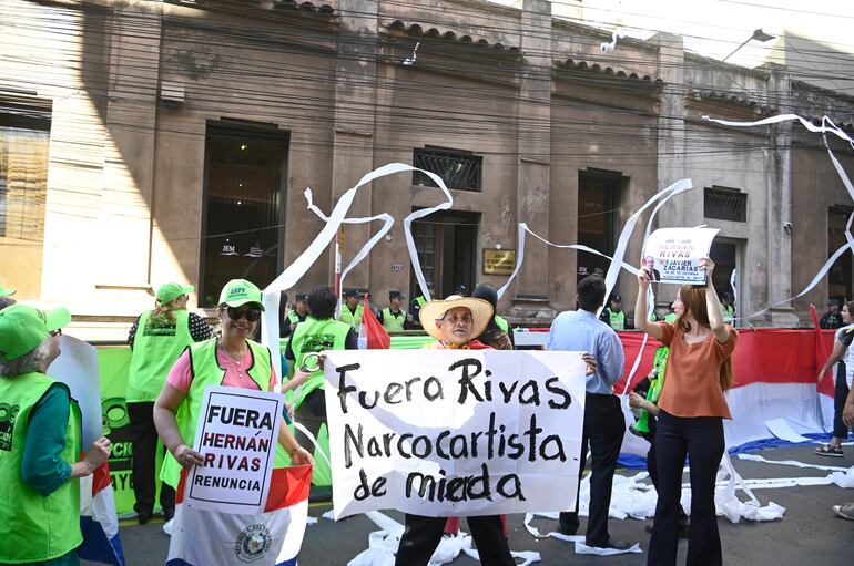 Ciudadanos autoconvocados con carteles en sus manos llegaron ayer frente al local del organismo juzgador de jueces y fiscales para exigir la renuncia del legislador colorado Rivas.