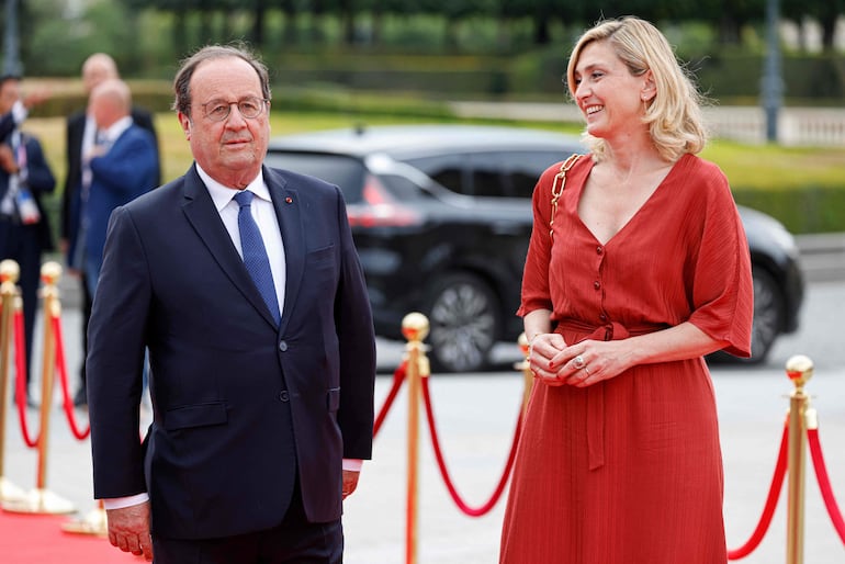 El expresidente francés Francois Hollande y su esposa, la actriz y productora francesa Julie Gayet, llegando para asistir a la cena de gala ofrecida por el Comité Olímpico Internacional (COI) y la presidencia francesa en el Museo del Louvre en París. (Ludovic MARIN / POOL / AFP)