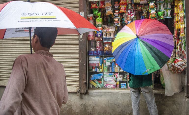 Personas son paraguas bajo la lluvia.