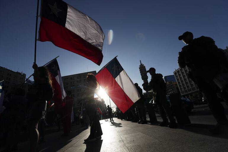 Integrantes del denominado Team Patriota celebran los resultados del plebiscito constitucional, en Santiago (Chile). Con más del 74% de los votos escrutados, los chilenos rechazaron  ayer por un 55,4% una segunda propuesta de nueva Constitución que votan en quince meses y decidieron mantener la carta magna actual, heredada de la dictadura militar (1973-1990) y ampliamente reformada en democracia. EFE/Elvis González