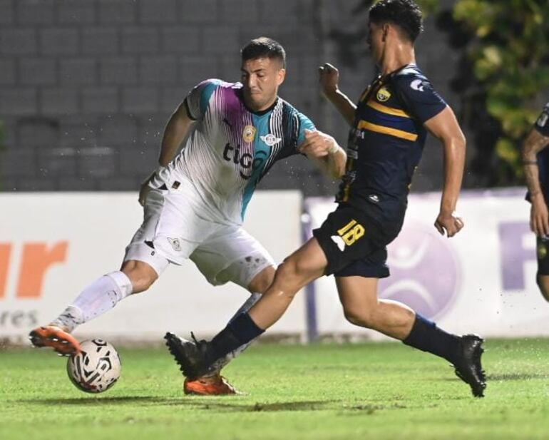 Álvaro Campuzano, jugador de Libertad, pelea el balón con David Fernández, del Sportivo Trinidense.