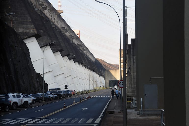 Parte posterior de la represa hidroeléctrica Itaipú. Sobre la casa de máquinas los tubos (blancos) de presión que descargan el agua desde el embalse sobre los rotores de los generadores,