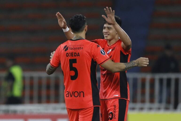 Sergio Ojeda (i) y Tiago Caballero, futbolistas de Nacional, celebran el triunfo y clasificación en un partido contra Atlético Nacional por la Fase 2 de la Copa Libertadores 2024 en el estadio Atanasio Girardot de la ciudad de Medellín, Colombia. 