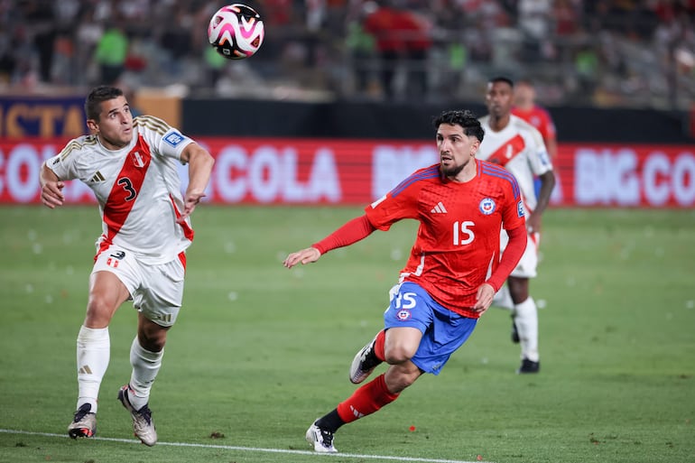 Aldo Corzo (i) de Perú disputa un balón con Diego Valdés de Chile este viernes, durante un partido de las eliminatorias sudamericanas al Mundial de Fútbol 2026, entre Perú y Chile en el Estadio Nacional, en Lima (Perú).