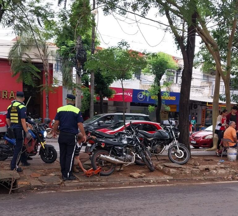 Los agentes de la PMT aplican cepos y retiran las motos estacionadas en las veredas de Asunción.