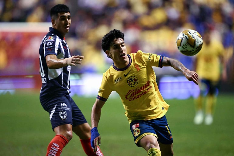 America's US midfielder #17 Alejandro Zendejas (R) eyes the ball past Monterrey's Argentine midfielder #30 Jorge Rodriguez during the Liga MX Apertura tournament final first-leg football match between America and Monterrey at the Cuauhtemoc Stadium in Puebla, Mexico, on December 12, 2024. (Photo by CARL DE SOUZA / AFP)