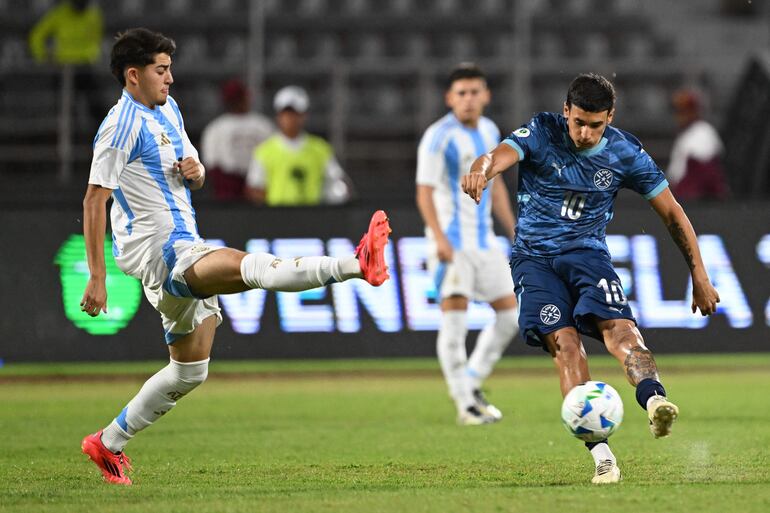 Argentina's midfielder #17 Valentino Acuña and Paraguay's forward #10 Luca Kmet fight for the ball during the 2025 South American U-20 football championship final round match between Argentina and Paraguay at the José Antonio Anzoátegui stadium in Puerto La Cruz, Anzoategui state, Venezuela on February 16, 2025. (Photo by Juan BARRETO / AFP)