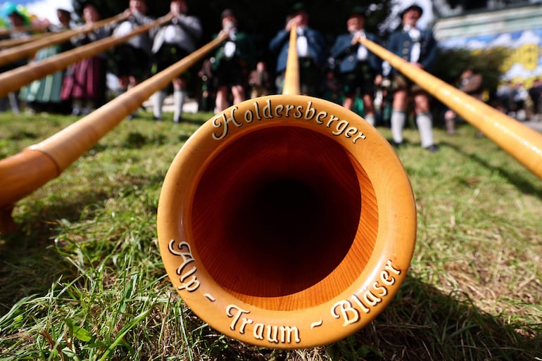 Varios músicos tocan la trompa de los Alpes durante el concierto en honor al Oktoberfest en Múnich, Alemania este domingo.