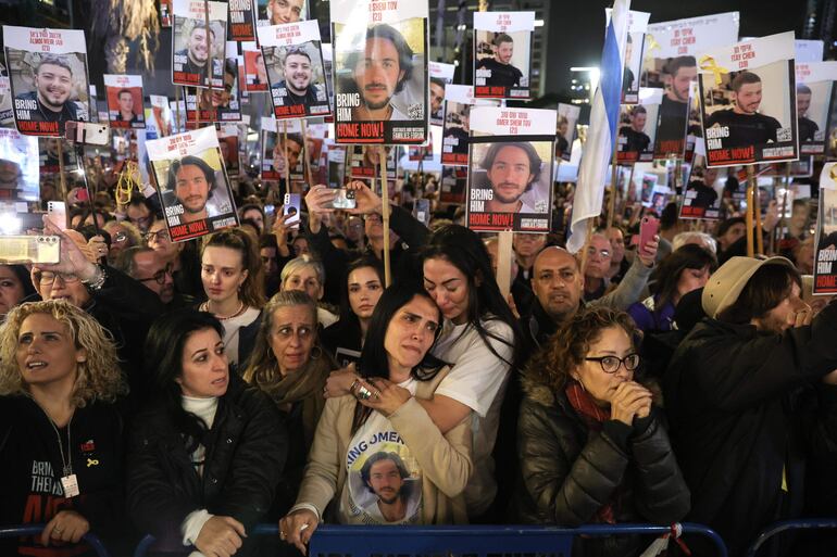 Tel Aviv (Israel), 13/01/2024.- Supporters and families react as others hold pictures of hostages held by Hamas in Gaza as they take part in a '100 Days of Hell' rally calling for their immediate release and marking the upcoming 100th day of their captivity, outside the Kirya military base in Tel Aviv, Israel, 13 January 2024. According to the Israeli government, 136 Israelis are still being held hostage by Hamas in the Gaza Strip. According to organizers, some 120,000 people attended the rally to mark the upcoming one-hundredth day, on 14 January 2024, since the 07 October Hamas attack on Israel. More than 23,600 Palestinians and at least 1,300 Israelis have been killed, according to the Palestinian Health Ministry and the Israel Defense Forces (IDF), since Hamas militants launched an attack against Israel from the Gaza Strip on 07 October, and the Israeli operations in Gaza and the West Bank which followed it. EFE/EPA/ABIR SULTAN
