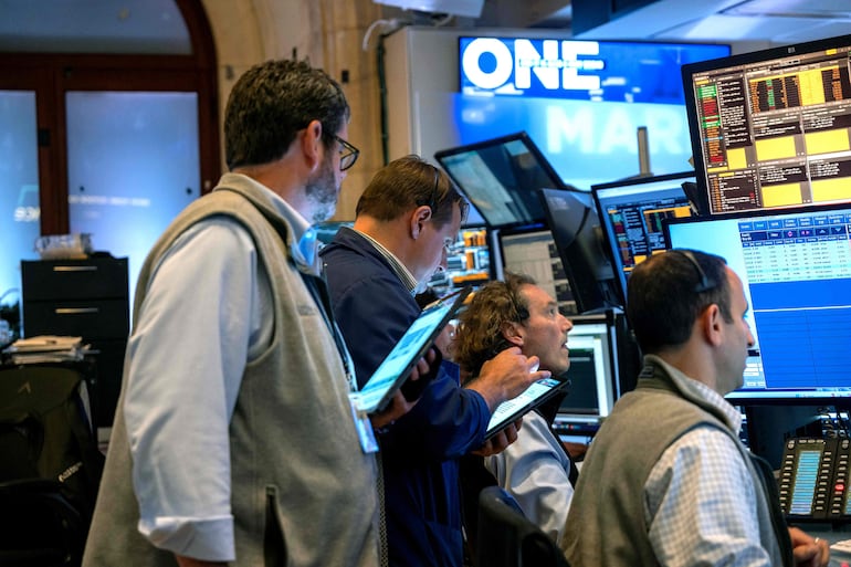 Trabajadores de la Bolsa de Valores de Nueva York (NYSE), ayer  19 de septiembre, en la ciudad de Nueva York. Las acciones subieron más de 500 puntos después de que la FED recortara su tasa de referencia en medio punto porcentual (foto AFP).