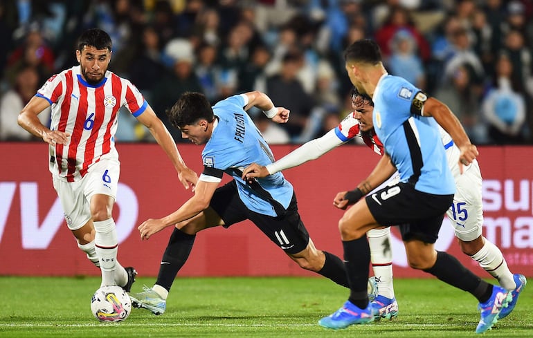 Junior Alonso (i), jugador de la selección de Paraguay, disputa la pelota en un partido frente a Uruguay por las Eliminatorias Sudamericanas 2026 en el estadio Centenario, en Montevideo.