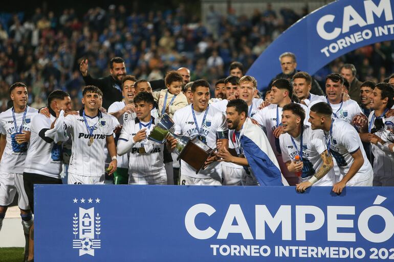 Miguel Samudio, tapado con la bandera paraguaya, aparece al lado de capitán Federico Pereira, tras recibir el trofeo de campeón.