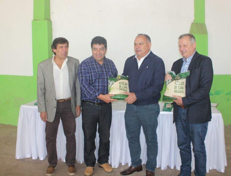 El presidente de cañicultores de Central, Gustavo Vallejos, y el gerente del ingenio azucarero La Felsina, Vicente Correa,  hacen entrega de la producción de azúcar orgánica al ministro del MAG, Moisés Bertoni y al director de la Dirección de Extensión Agraria (DEAG), Gerardo Rojas.