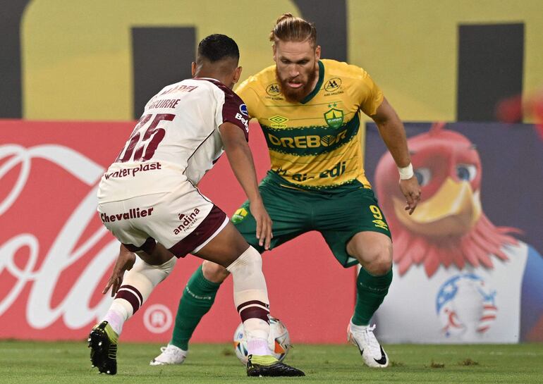 Lanus' forward Braian Aguirre (L) and Cuiaba's Paraguayan forward Isidro Pitta fight for the ball during the Copa Sudamericana group stage first leg match between Brazil's Cuiaba and Argentina's Lanus at Arena Pantanal stadium in Cuiaba, Brazil, on April 3, 2024. (Photo by EVARISTO SA / AFP)