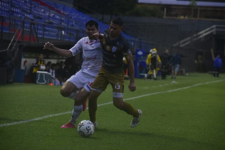 Feliciano Brizuela (Nacional) disputa el balón con Walter Cabrera (Ameliano).