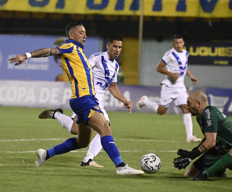 El experimentado atacante Lucas Barrios (39 años) intenta la definición ante la salida del charrúa Federico Cristóforo (34) y la mirada del zaguero debutante Cléver Ferreira (21).