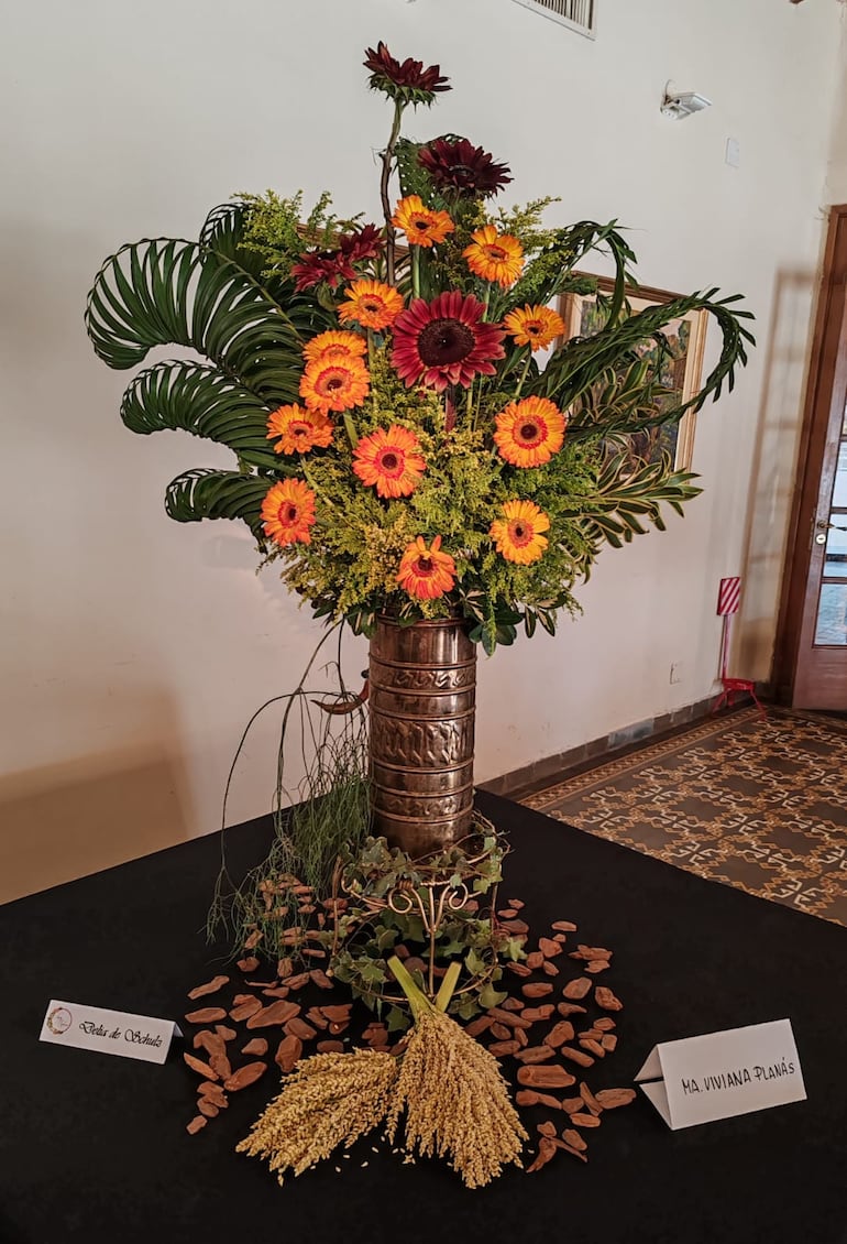 Girasoles de tono naranja y rojo con hojas de palmera trenzadas.