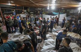 Personas se reúnen alrededor de los cuerpos de palestinos muertos por ataques aéreos israelíes contra el hospital árabe Al Ahli en el centro de Gaza (Foto: Dawood Nemer / AFP)