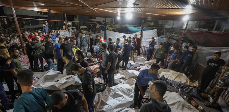 Personas se reúnen alrededor de los cuerpos de palestinos muertos por ataques aéreos israelíes contra el hospital árabe Al Ahli en el centro de Gaza (Foto: Dawood Nemer / AFP)