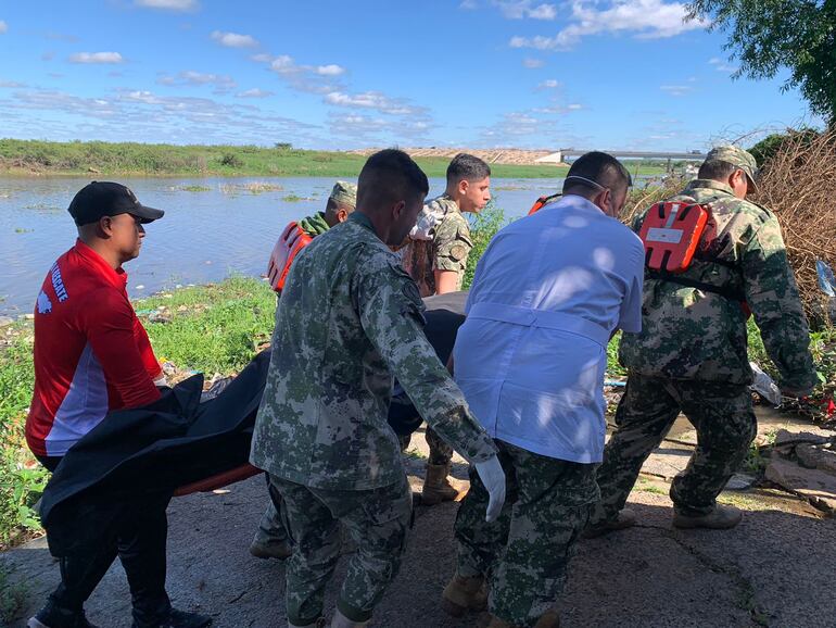 Momento del traslado del cuerpo del sargento primero Domingo David Ríos Domínguez, quien falleció tras ser arrastrado por los raudales de Lambaré este jueves.