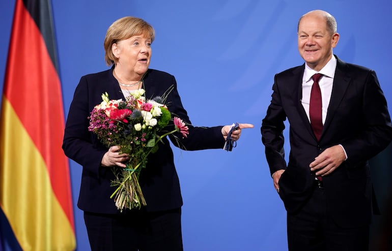 El canciller alemán, Olaf Scholz, junto a su antecesora en el cargo, Angela Merkel, durante su ceremonia de investidura en el cargo, en Berlín. El Partido Socialdemócrata (SPD) recuperó el liderazgo en Alemania a través de Olaf Scholz, el nuevo canciller federal al frente de una coalición inédita con verdes y liberales, que cierra el periodo de 16 años en el poder de la conservadora Angela Merkel. EFE/CLEMENS BILAN